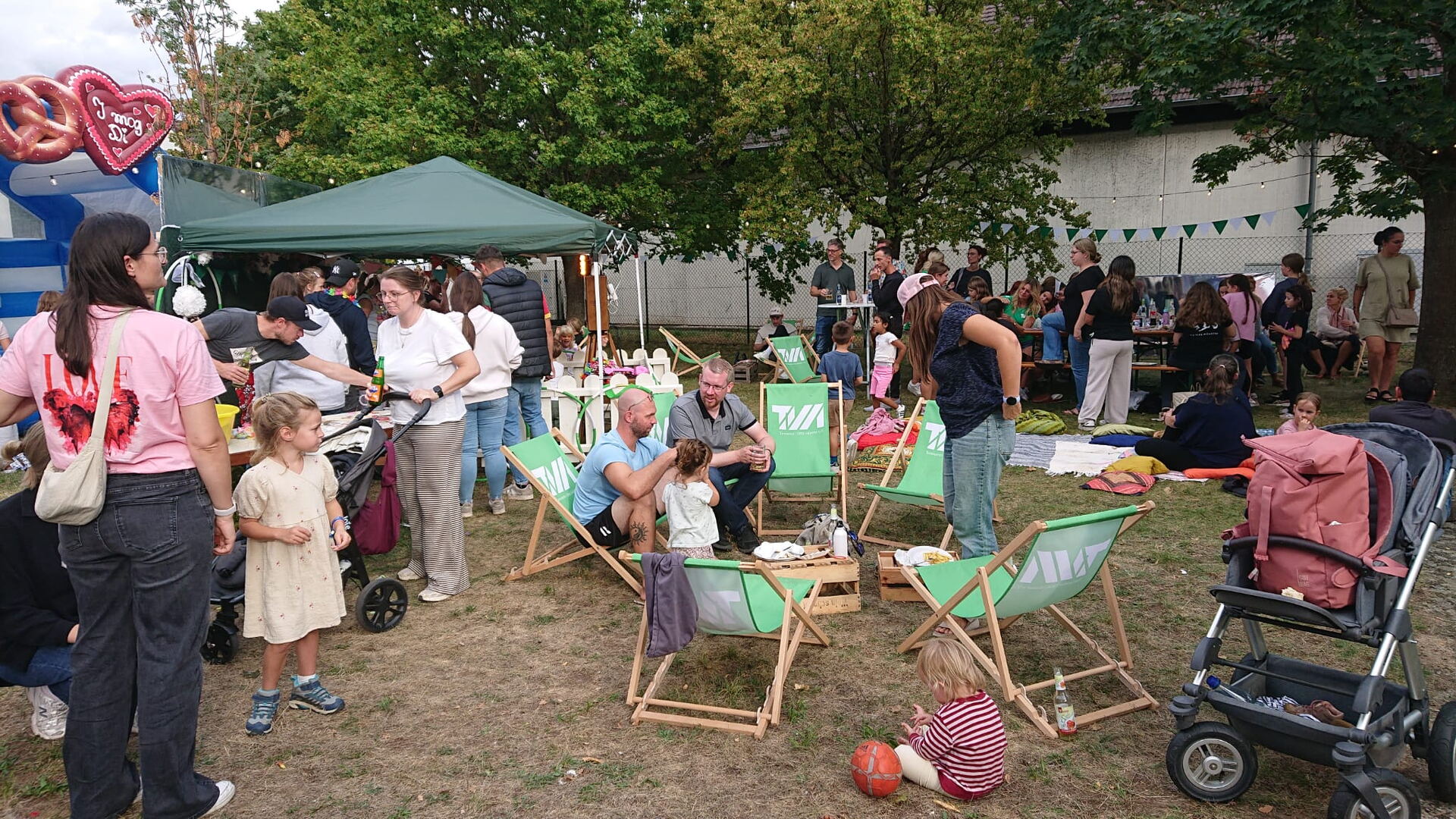Gäste in grünen TVM-Liegestühlen beim Sommerfest